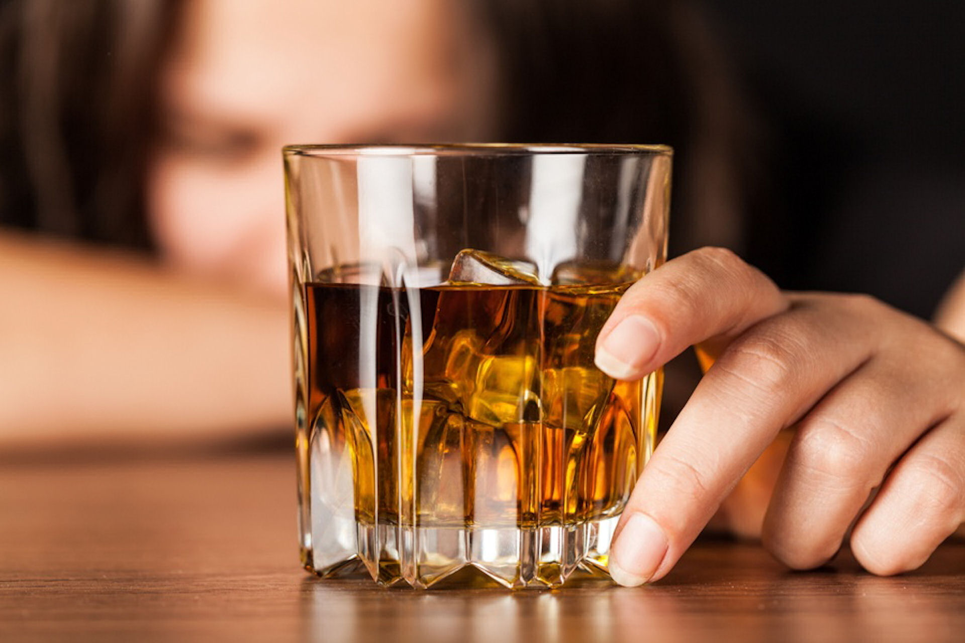 a woman with alcohol addiction holding a glass of alcohol